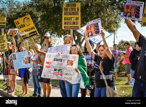 Protesters holding signs denouncing Donald Trump at a political rally ...