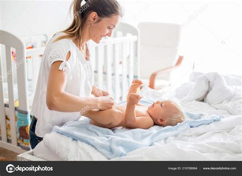 Young Mom Changing Baby Diaper Bath Sunny Bedroom Stock Photo by ©t.tomsickova 215788994