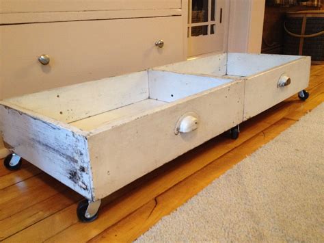 an old wooden box with wheels on the floor in front of a door and rug