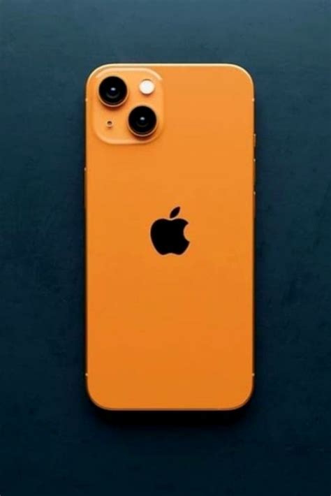 an orange iphone on a black surface with the back camera facing towards the camera lens