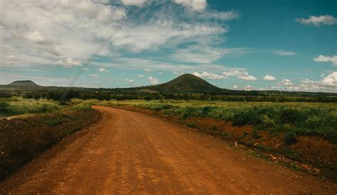 Photo of Dirt Road Across Hill Under Cloudy Sky · Free Stock Photo