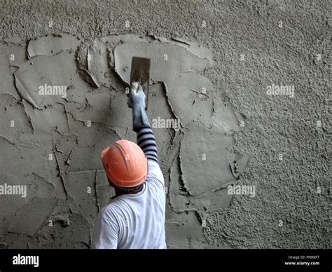 Construction workers plastering wall using cement plaster at the ...