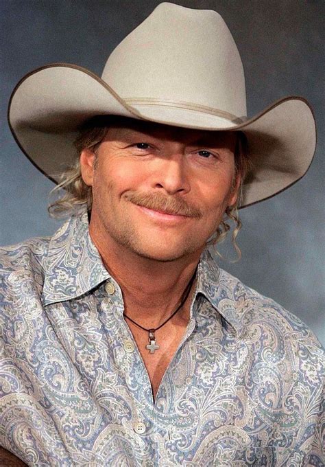 a man in a cowboy hat is smiling at the camera