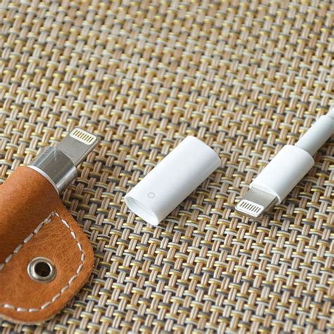 two different types of electronic devices sitting on a cloth covered tablecloth, one is plugged ...