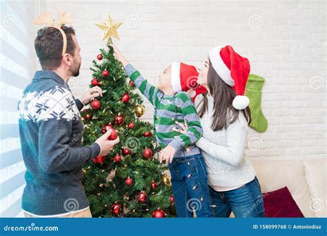 Family Adorning Tree Together at Home during Christmas Stock Photo - Image of celebration ...