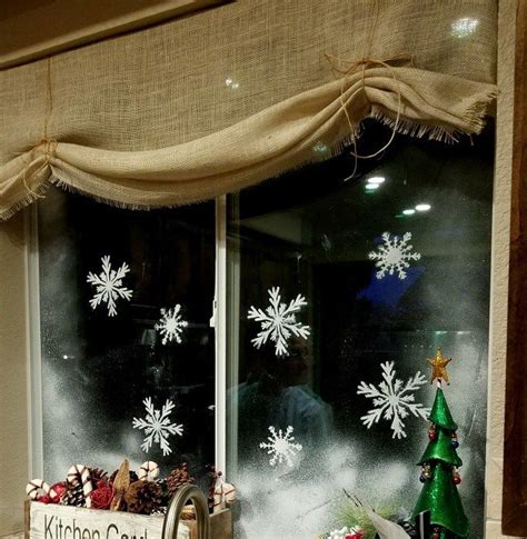 a kitchen window decorated for christmas with snowflakes