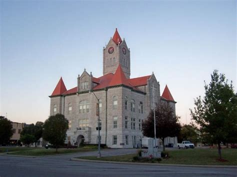 an old building with a red roof and steeple on the top is shown at dusk