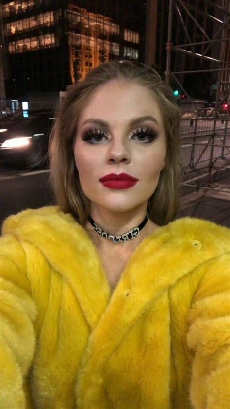 a woman wearing a yellow fur coat and red lipstick