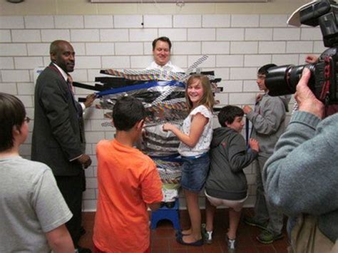 Wilbraham Middle School Principal Daniel Roy is taped to the wall to raise scholarship funds for ...