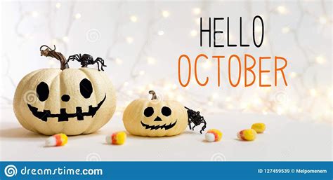 Photo about Hello October message with halloween pumpkins with spider on a shiny light ...