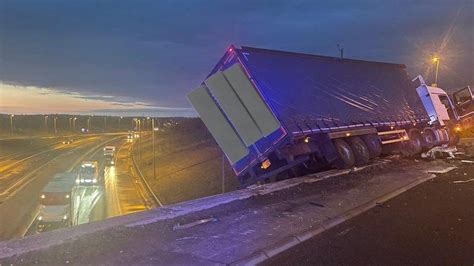 M1 crash leaves lorry hanging off bridge - BBC News