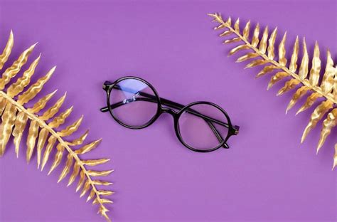 Premium Photo | Stylish round female glasses on a purple background ...