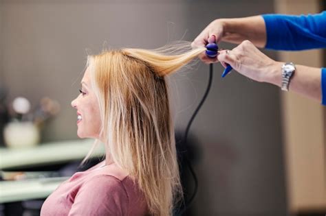 Premium Photo | Cropped picture of a hair stylist ironing her hair in a ...