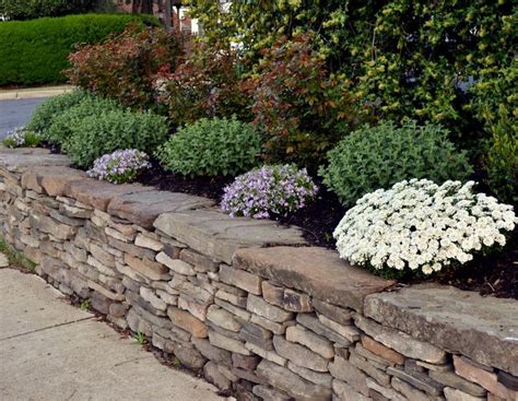 Dry-stacked fieldstone retaining wall and plantings designed by Mary Kirk Menefee; installed by ...