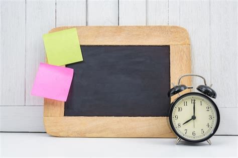 Premium Photo | Blank space chalkboard, alarm clock and blank sticky note, post note on office ...
