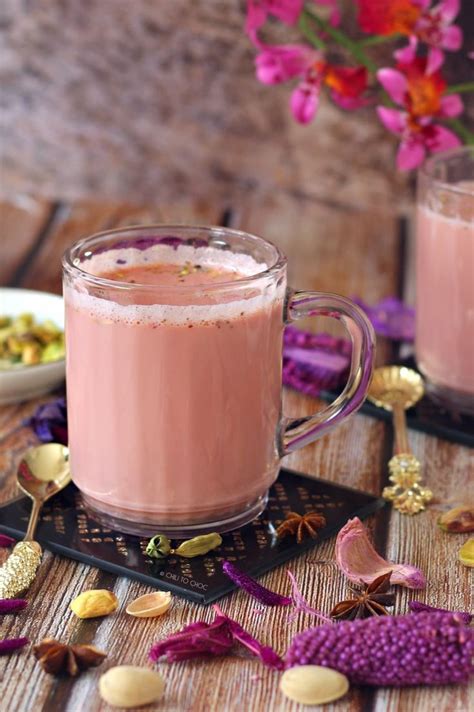 two mugs filled with pink liquid sitting on top of a wooden table