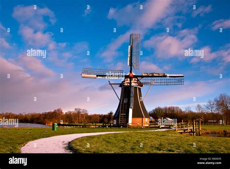 Dutch Windmill on the Waterfront of a Lake with Spectacular Clouds ...