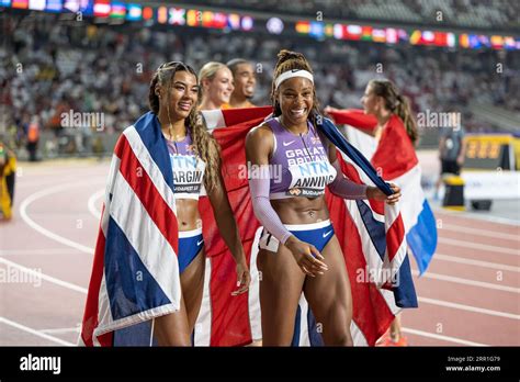 Amber Anning and Nicole Yeargin with her country's flag in the 4x400 meter relay at the World ...