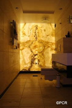 Backlit Onyx feature wall in bathroom or small space. Onyx is a translucent stone and transforms ...