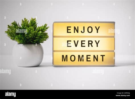 Motivational and Inspirational Quotes. Enjoy Every Moment. Still Life of Lightbox on Work Desk ...