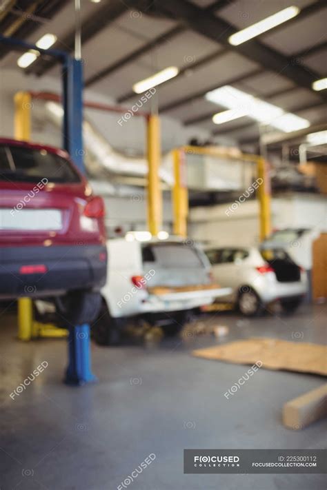 Car on hydraulic lift in repair garage — industrial, automobile - Stock Photo | #225300112