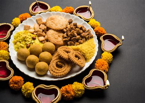 Diwali Rangoli or design made using Indian snacks/sweet and diya or ...