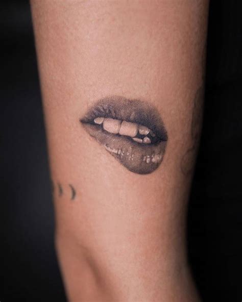 Black and grey style lips tattoo located on the upper