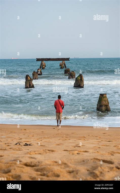 Togo, Lom?, man on the beach in font of the old wharf Stock Photo - Alamy