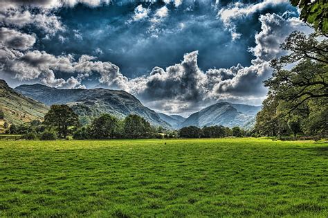 HD wallpaper: grassy plains across the mountains under blue sky ...