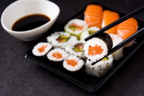 Premium Photo | Sushi assortment on black tray and soy sauce.