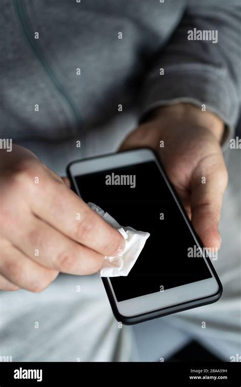 Man cleaning smartphone screen with alcohol or disinfectant. The concept of cleaning a dirty ...