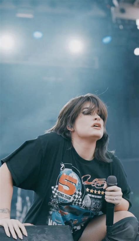 a woman sitting on top of a stage holding a microphone