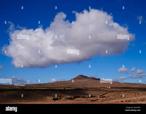 Lonely volcano landscape with blue sky and big white cloud Stock Photo - Alamy