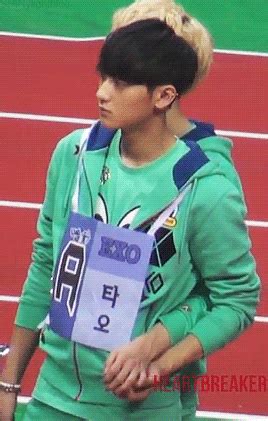 a boy with headphones on standing in front of a red and green track surface