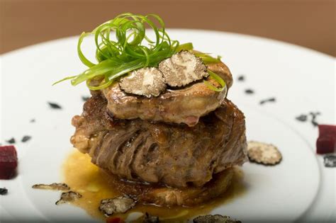 Premium Photo | Sliced truffles topped on a grilled steak, beef and pork, with vegetable and sauce