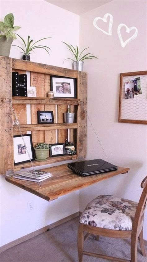 a wooden desk topped with a laptop computer sitting next to a potted plant on top of a wooden shelf