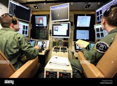 A student pilot and sensor operator man the controls of a MQ-9 Reaper in a ground-based cockpit ...