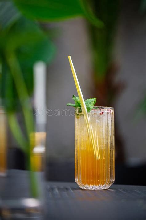 Glass with Orange Mojito Cocktail with Lemon and Mint, Cold Refreshing Drink or Beverage with ...