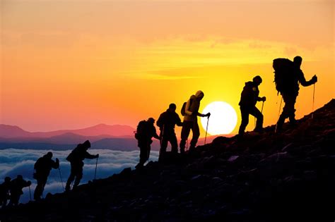 Silhouettes Of Hikers At Sunset Stock Photo - Download Image Now - iStock