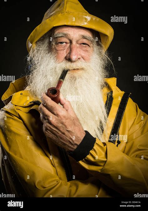 old fisherman with white beard wearing sou'wester hat and guy cotten ...