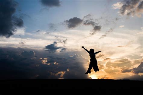 Silhouette of happy woman jumping at sunset 1991008 Stock Photo at Vecteezy