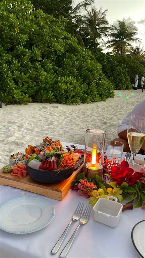 a table set up with plates and glasses on the beach for an outdoor ...