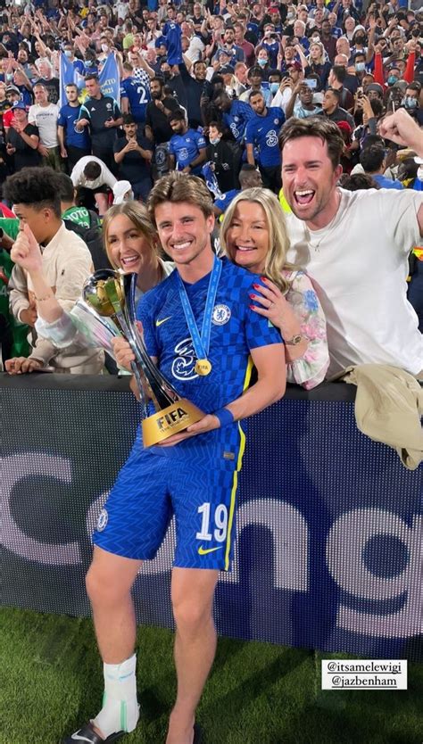 two men and a woman are posing for a photo in front of a large crowd