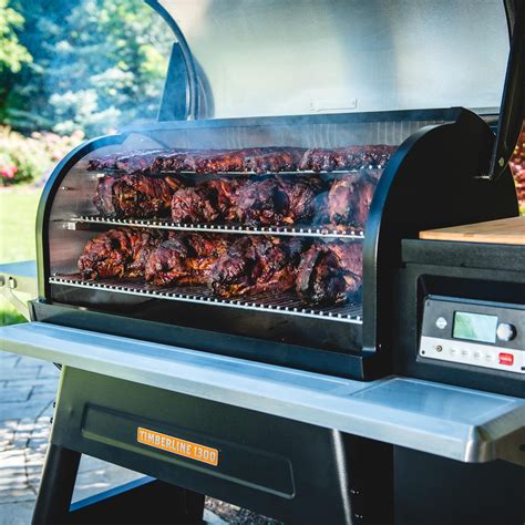 a bbq grill with meat cooking on it's side and the lid open