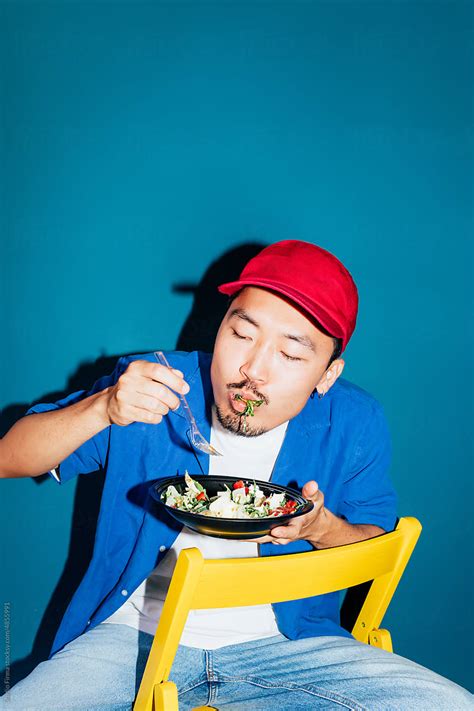 "Man Eating Salad" by Stocksy Contributor "Studio Firma" - Stocksy