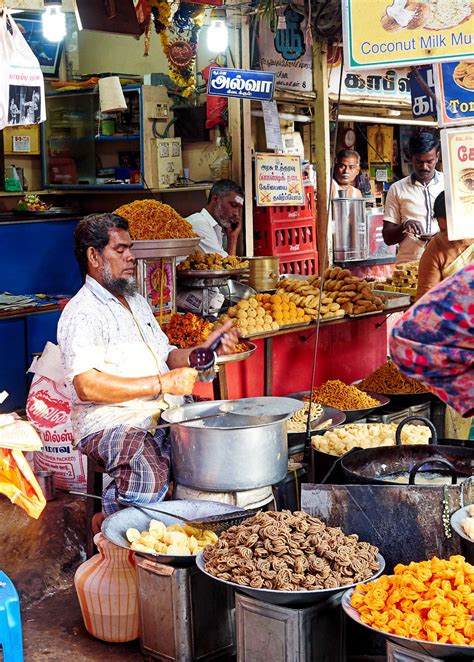 A cook preparing snacks and sweets at the street side shop, Madurai ...