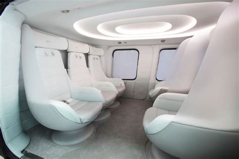 the interior of an airplane with white leather seats and round lights on either side of the windows