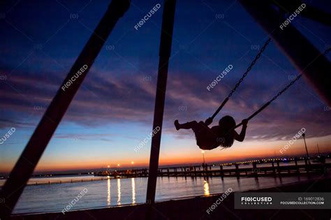 Child playing on swing at sunset, Seaside Park, New Jersey, USA — Pre ...