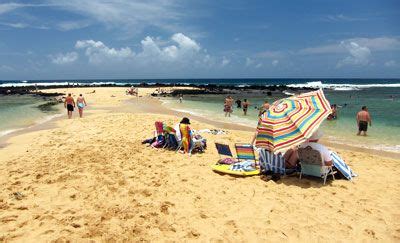 people are on the beach with umbrellas and chairs in the sand near the ...