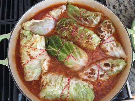 a pot filled with cabbage covered in red sauce on top of a stove burner